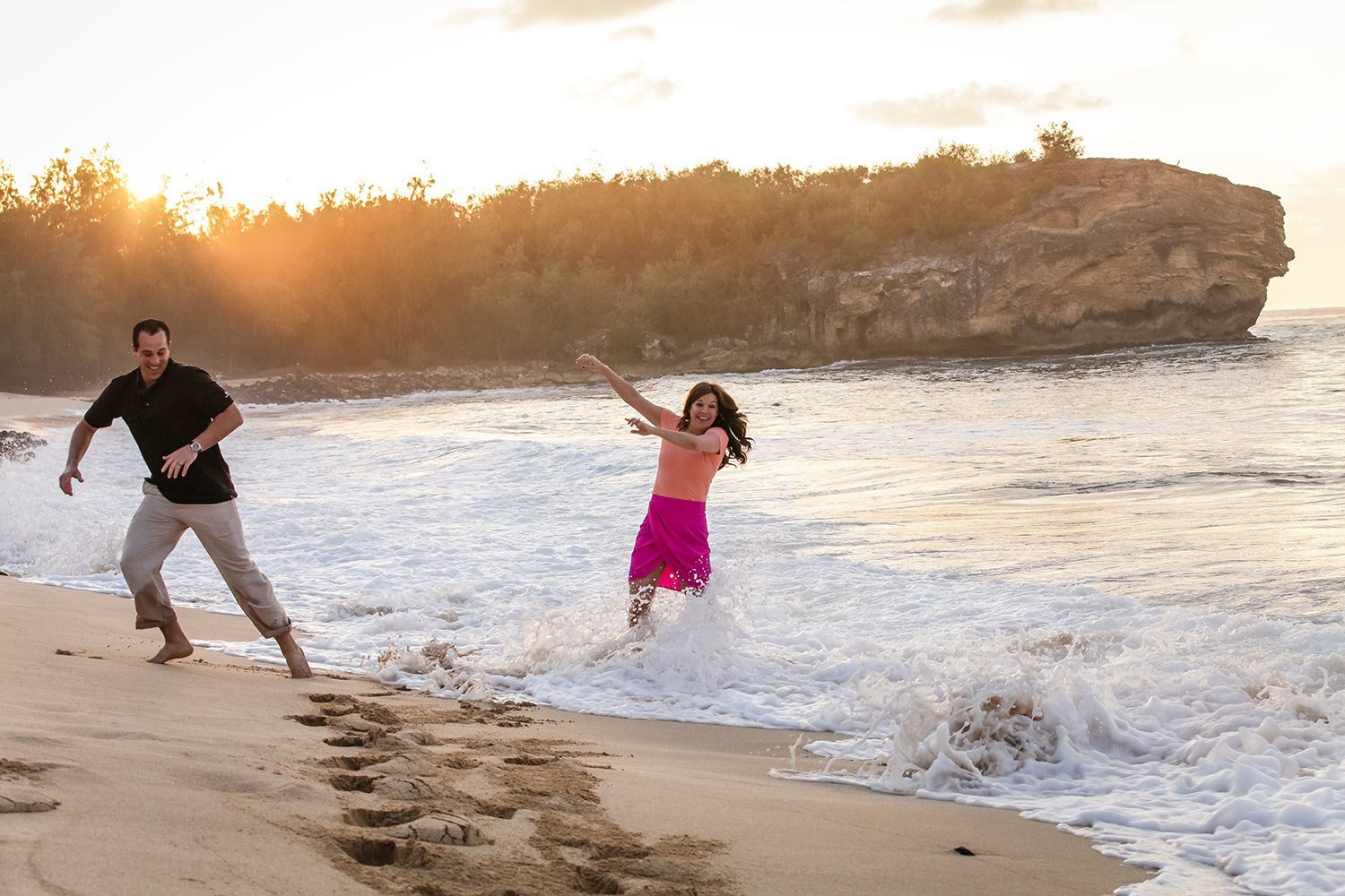 Father and daughter playing in the surf at Shipwreck Beach, Kauai